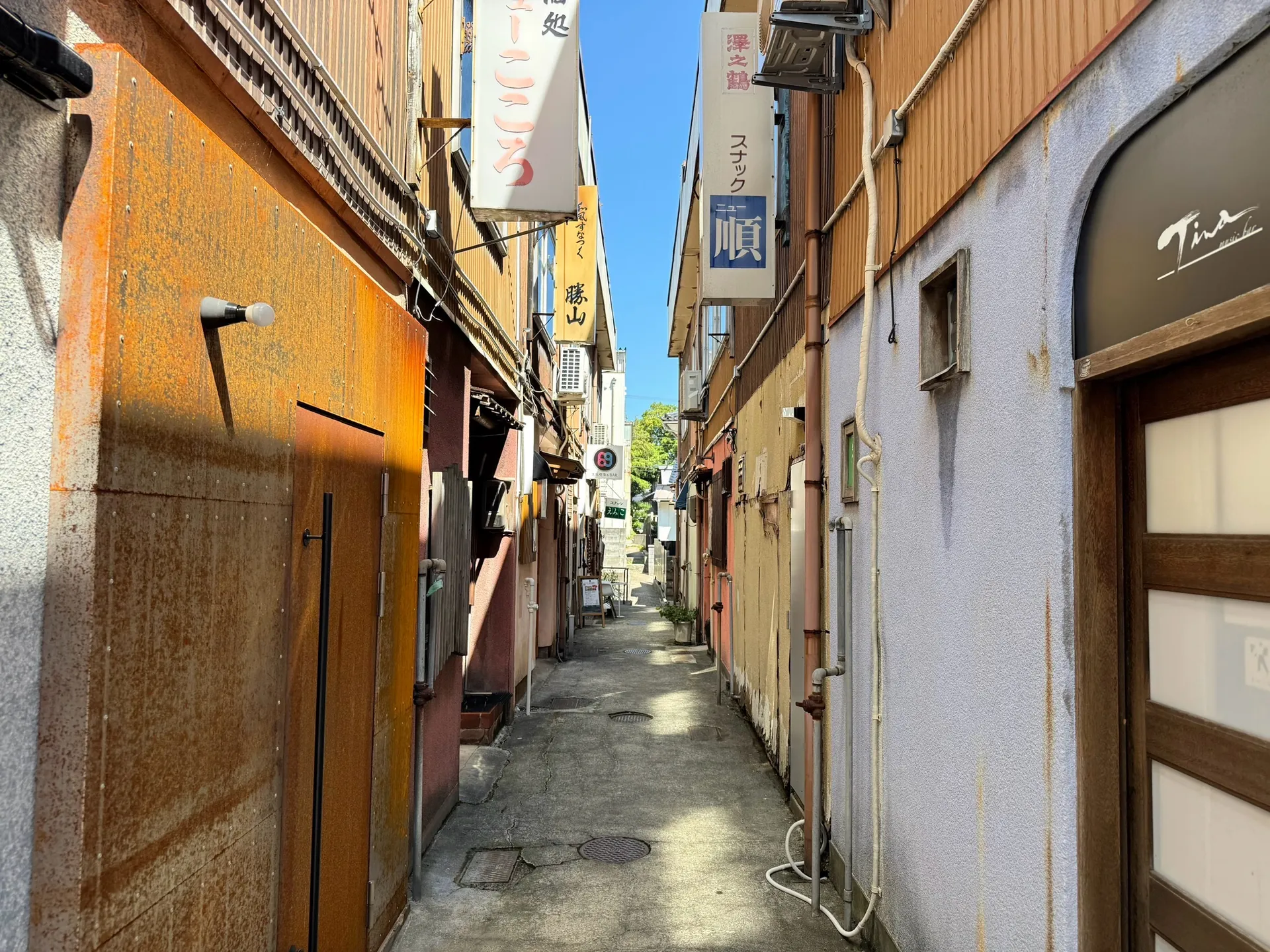 建物と看板が並ぶ、昼の路地